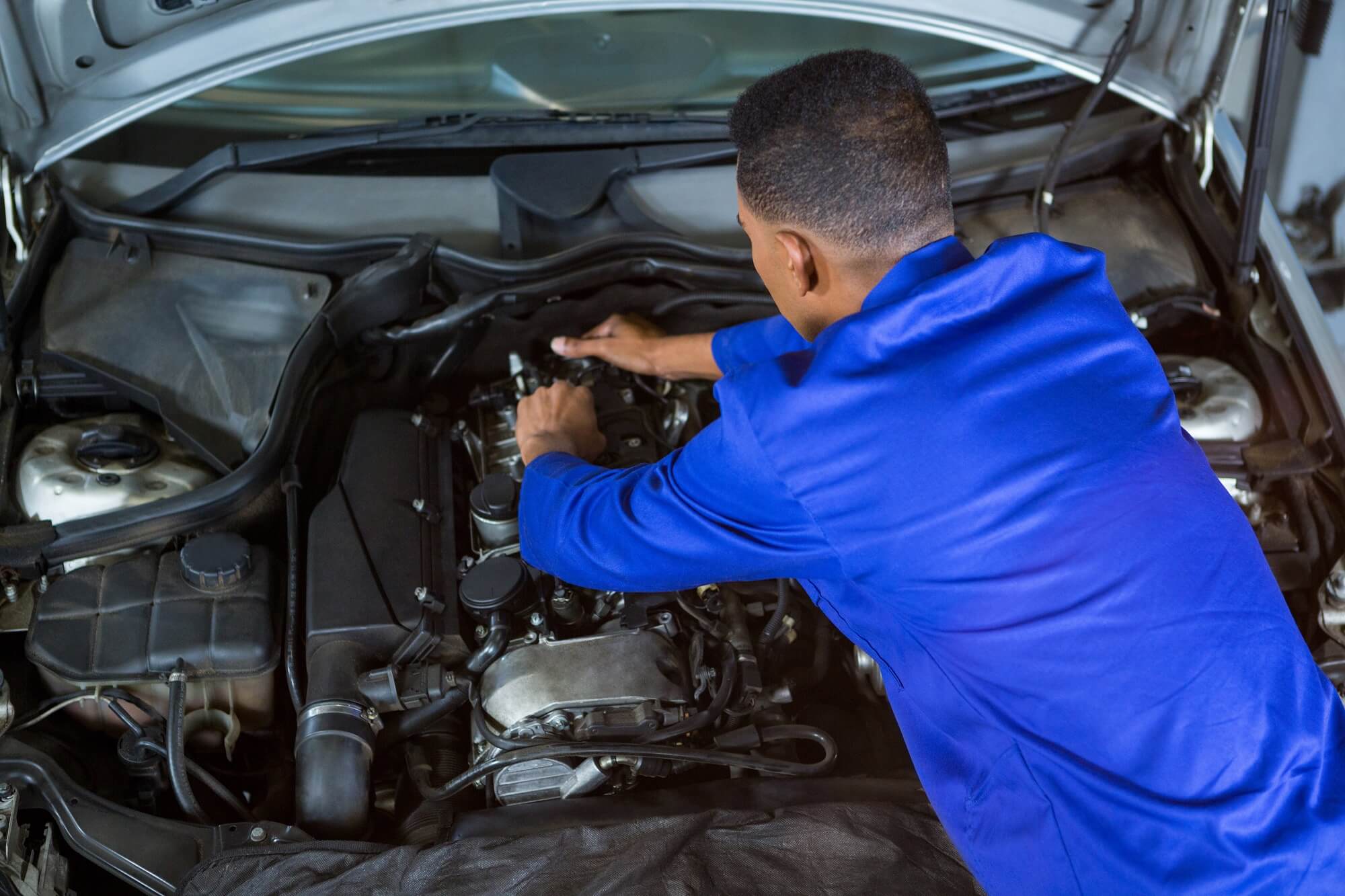 mecânico dando manutenção no motor automotivo